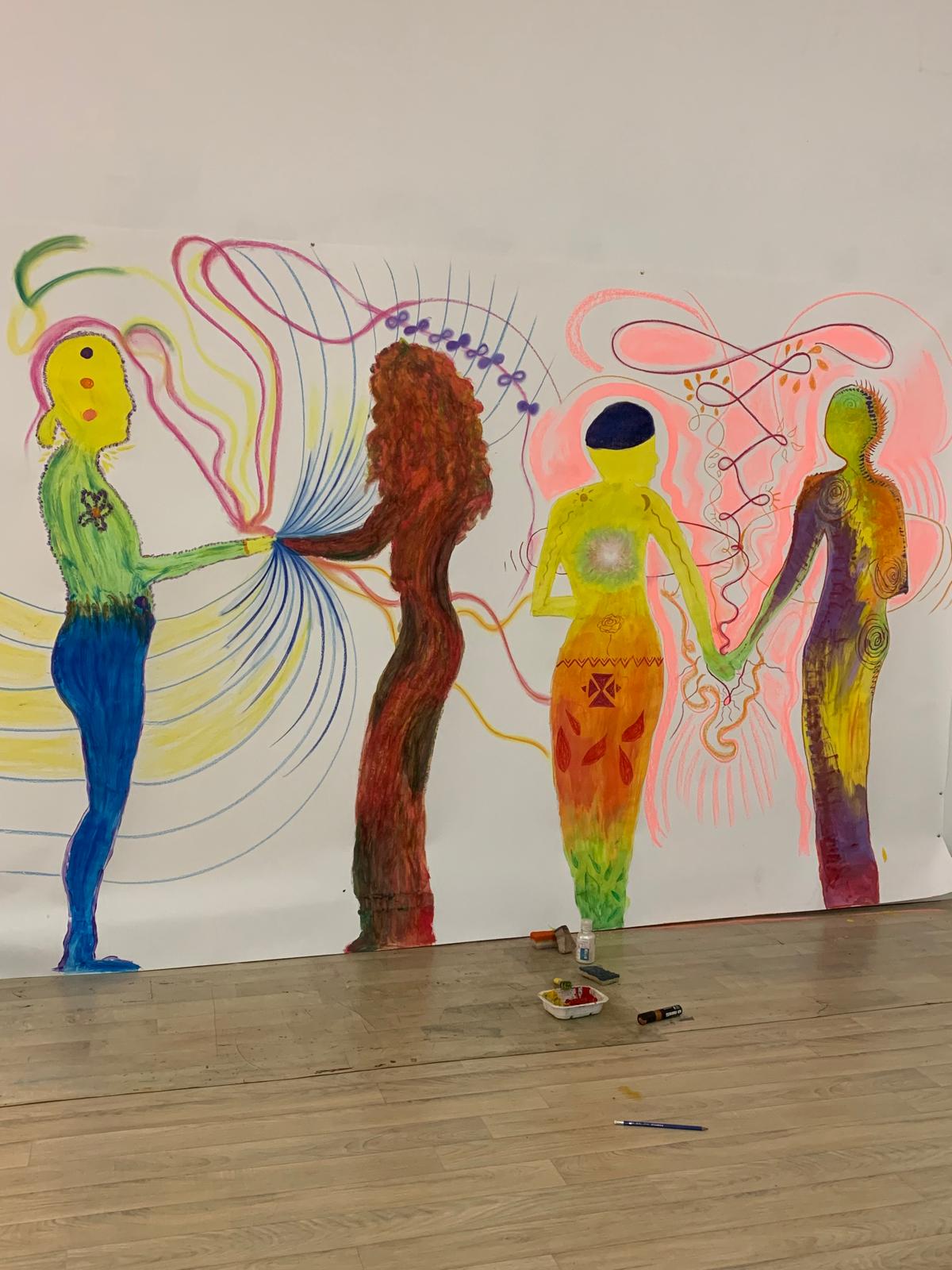Fresque peinte : quatre silhouettes colorées se tenant par la main, reliées par des traits de couleur